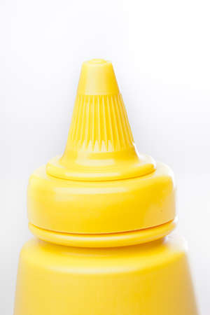 A yellow mustard bottle against a white backgroundの写真素材