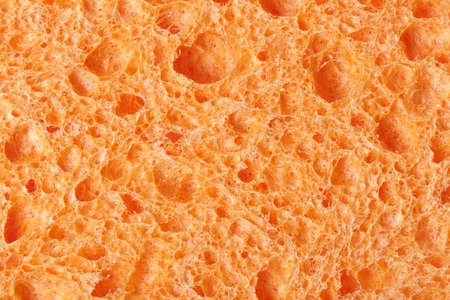 A colorful sponge used for cleaning against a white background