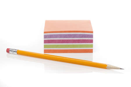 A colorful note pad with a pencil against a white background