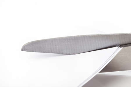 A pair of scissors  cutting a piece of paperの写真素材