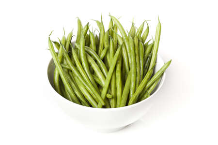 A fresh green string bean against a white background