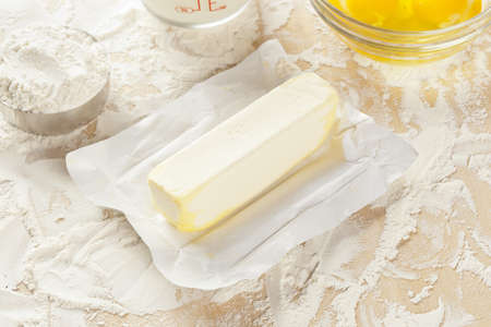 Fresh natural butter in front of baking ingredients