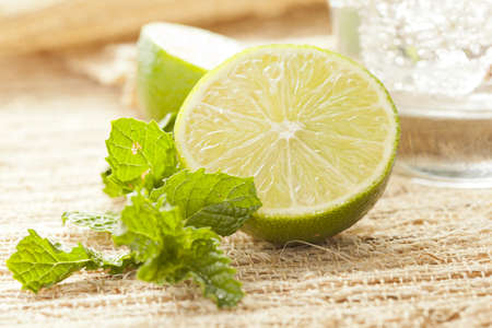 Fresh Lime and Mint Leaf next to a mojitoの写真素材