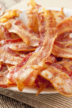 Cooked Greasy Bacon against a back groundの写真素材