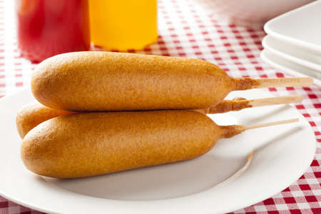 Organic CornDog on a stick with ketchup and mustardの写真素材