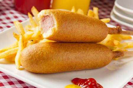 Organic CornDog on a stick with ketchup and mustardの写真素材
