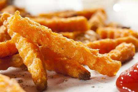 Cripsy Organic Sweet Potato Fries with pepper on parchment paper