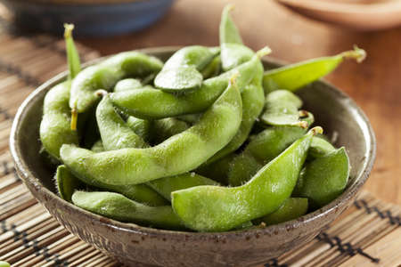 Cooked Green Organic Edamame with sea salt against a background
