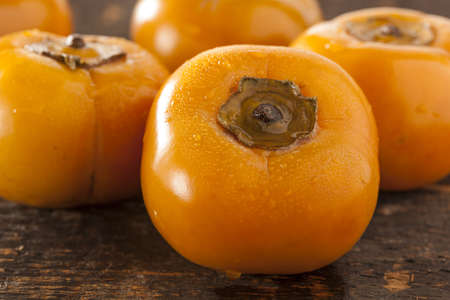Organic Orange Persimmon Fruit against a backgroundの写真素材
