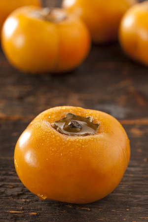 Organic Orange Persimmon Fruit against a backgroundの写真素材