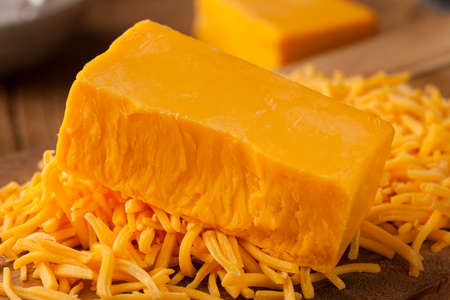 Organic Sharp Cheddar Cheese on a Cutting Boardの写真素材