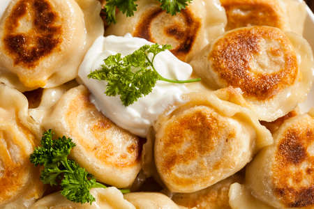 Homemade Polish Pierogis with Sour Cream and Parsleyの写真素材