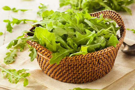 Organic Raw Green Arugula in a Basketの写真素材