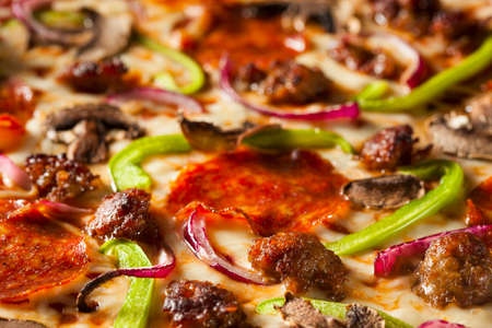 Homemade Hot Supreme PIzza with Pepperoni Peppers and Sausageの写真素材