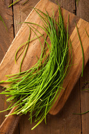 Raw Organic Green Chives on a Cutting Board