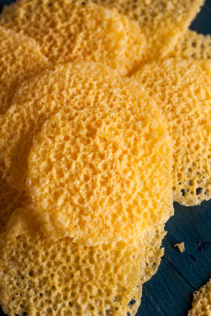 Homemade Parmesan Cheese Crisps on a Cutting Boardの写真素材