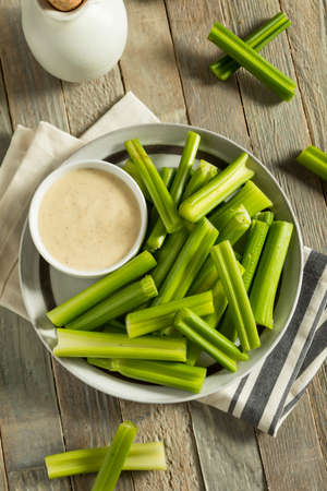 Raw Organic Green Celery Stalks with Ranch Dipの写真素材