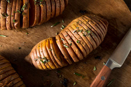 Homemade Organic Hasselback Sweet Potato with Fresh Herbsの写真素材
