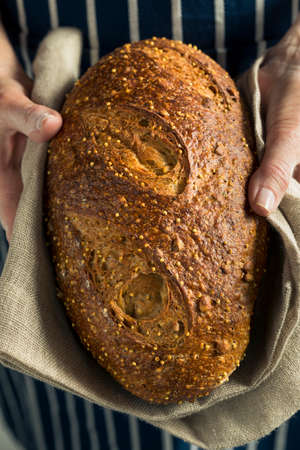 Handmade Organic Bread in a Womans Hands Ready to Eatの写真素材