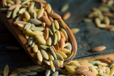 Dry Organic Tricolor Orzo Pasta in a Bowlの写真素材