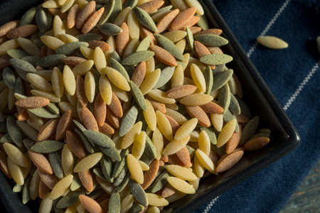 Dry Organic Tricolor Orzo Pasta in a Bowl