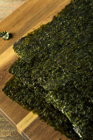 Organic Green Dry Roasted Seaweed Sheets on a Boardの写真素材