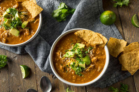 Spicy Homemade Tortilla Soup with Cheese Cilantro and Limeの写真素材