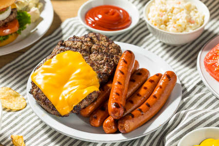 Memorial Day Backyard Babecue Meal with Hamburgers Hot dogs Salads and Chipsの写真素材