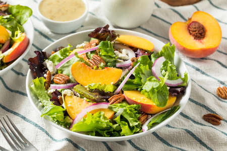 Healthy Homemade Peach Salad with Pecans Cheese and Dressingの写真素材