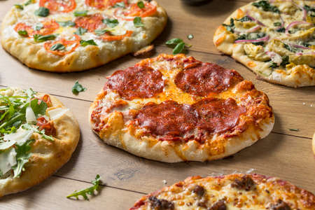 Gourmet Homemade Assorted Wood Fired Pizzas with Pepperoni Basil and Cheeseの写真素材