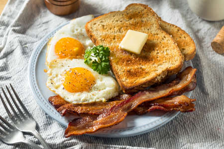 Homemade Sunnyside Eggs Breakfast with Toast and Baconの写真素材