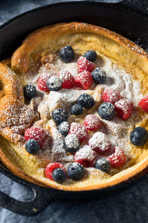 Homemade Baked Dutch Baby Pancake with Berries and Powdered Sugar