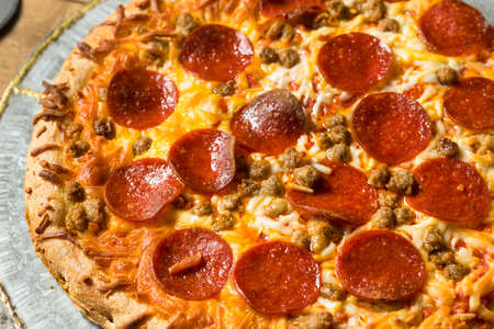 Homemade Meat Lovers Pepperoni Pizza with Sausage and Baconの写真素材