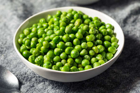 Raw Green Organic Sweet Peas in a Bowlの写真素材