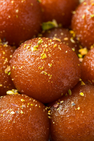 Homemade Indian Gulab Jamun Dessert in Syrup with Pistacchiosの写真素材