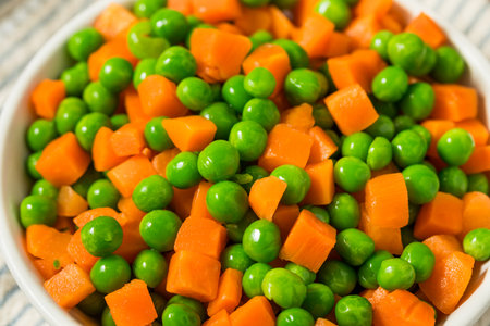 Organic Raw Steamed Frozen Green Peas and Carrots in a Bowlの写真素材
