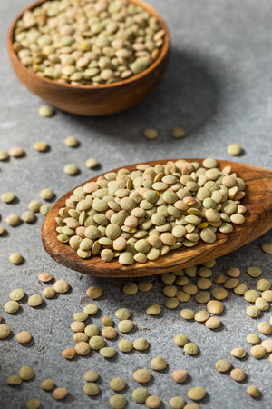 Dry Raw Organic Green Lentils on a Spoon for Cookingの写真素材