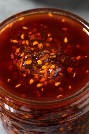 Homemade Spicy Chili Crisp Oil Sauce with Peppers and Seedsの写真素材