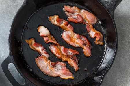 Greasy Fatty Cooked Crispy Bacon in a Skilletの写真素材