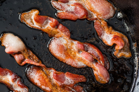 Greasy Fatty Cooked Crispy Bacon in a Skilletの写真素材