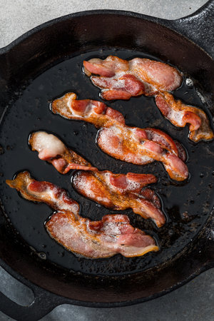 Greasy Fatty Cooked Crispy Bacon in a Skillet
