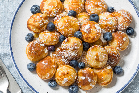Homemade Poefferjes Mini Pancakes with Powdered Sugar and Blueberries