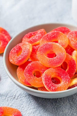Sweet Round Peach Ring Candy in a Bowl with Sugarの写真素材
