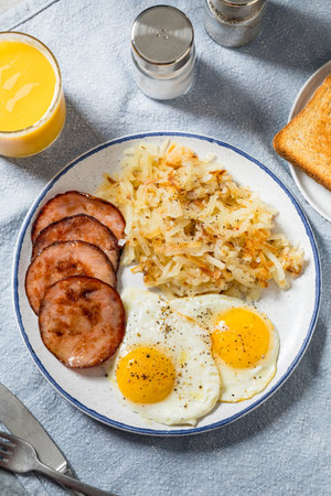 Homemade Eggs Canadian Bacon and Hash Brown Breakfast with Toastの写真素材