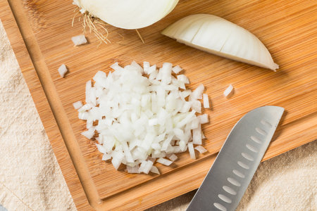 Organic Chopped Diced Onions on a Cutting Boardの写真素材