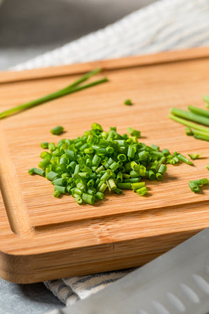 Raw Diced Cut Chives on a Cutting Boardの写真素材