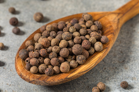 Dry Organic Allspice Berries in a Spoon to Cook With