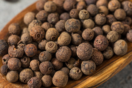 Dry Organic Allspice Berries in a Spoon to Cook Withの写真素材