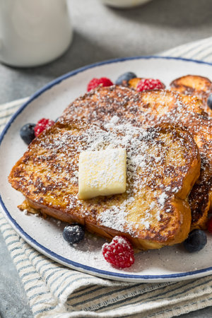 Sweet Homemade Challah French Toast with Powdered Sugar and Berriesの写真素材