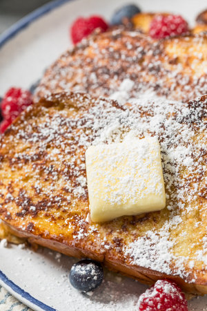Sweet Homemade Challah French Toast with Powdered Sugar and Berriesの写真素材